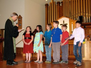 Rev. Tom Kinder presenting Bibles to the older children